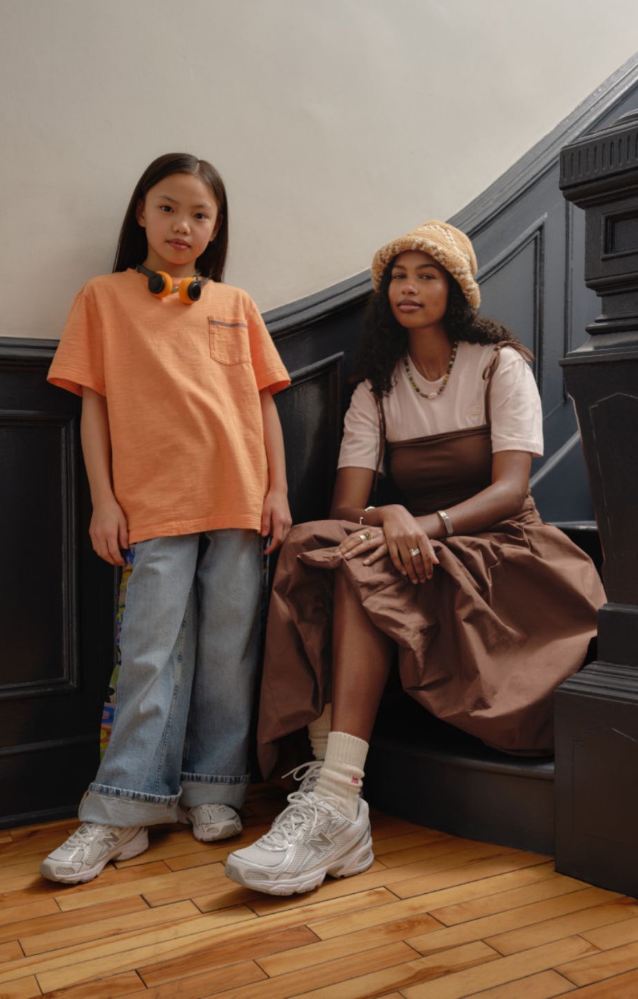 woman sitting on stairs with a young girl standing next to her. Both are wearing new balance 740 sneakers